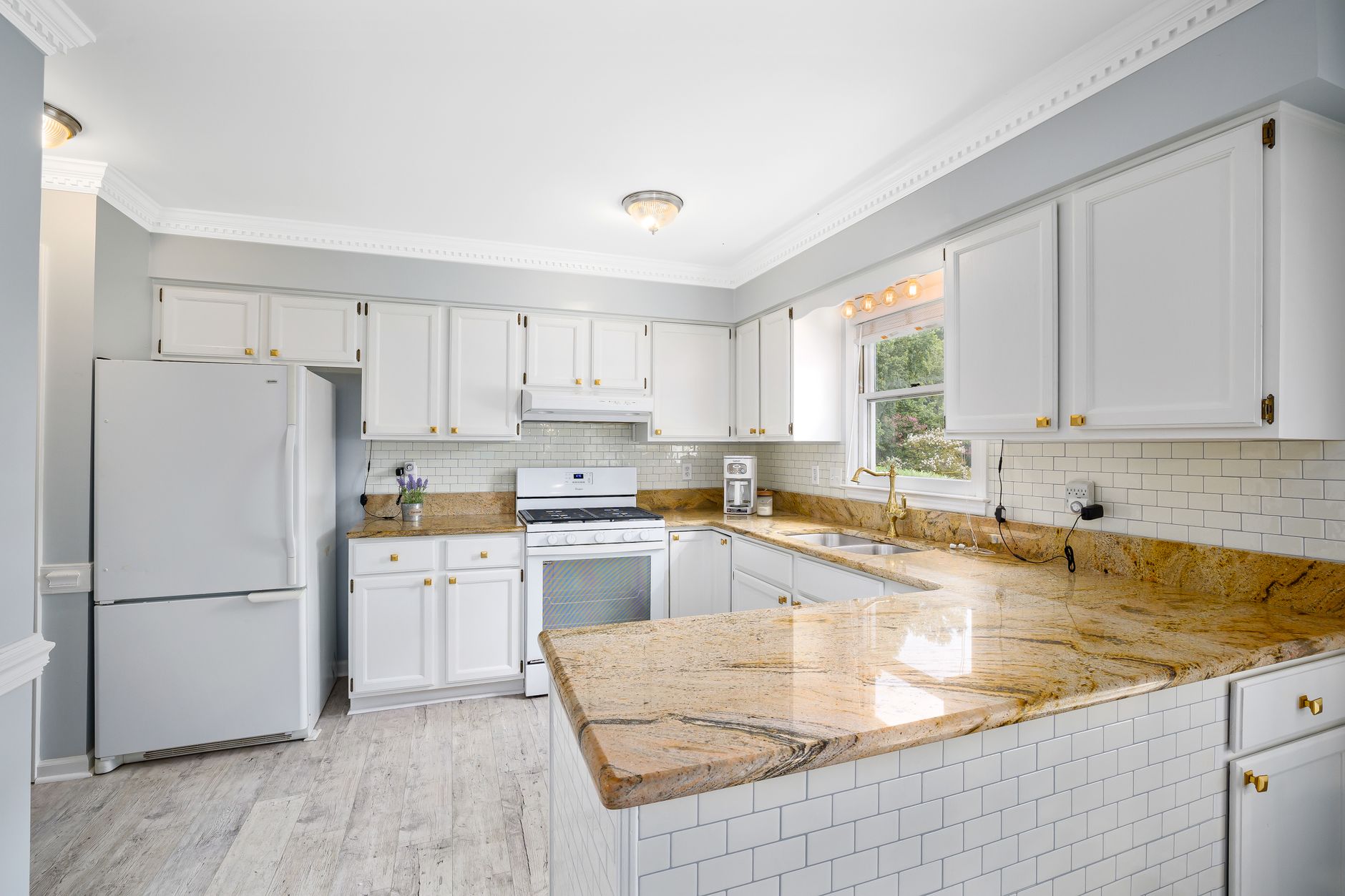 A bright kitchen with white cabinets, marble countertops, and modern appliances in Bellevue, WA